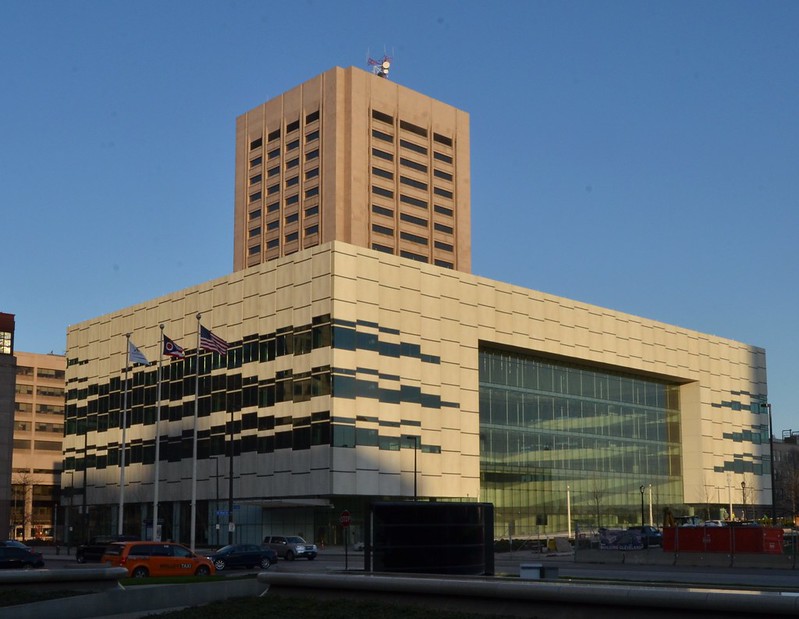 The American flag flies outside a convention center building in late afternoon light.